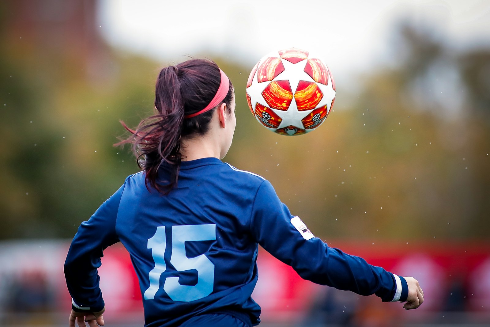 Jugendliche Fußballspielerin köpft einen Ball